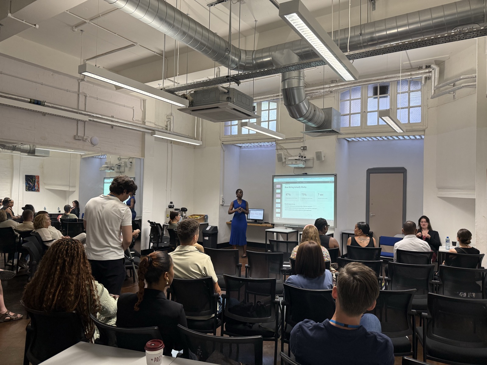 A full room of attendees at Steph's CV writing workshop, with a 'How Hiring Actually Works' slide on screen