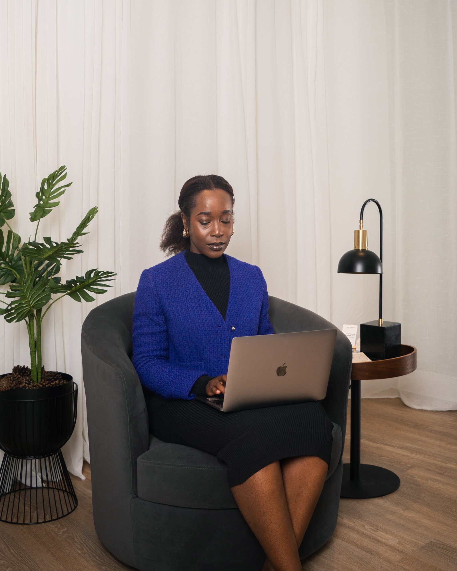 Steph, career and lifestyle design coach, working on a laptop in a purple blazer